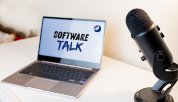 Mikrofon auf Tisch neben Notebook mit dem Schriftzug "Software-Talk"